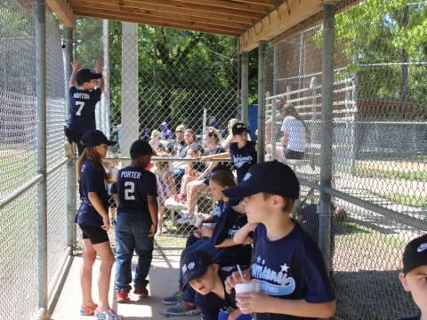 a group of kids in a batting cage