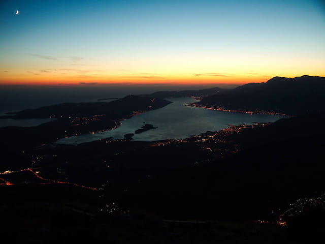 a river with a city in the distance at sunset