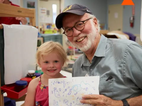 a man and a girl holding a book