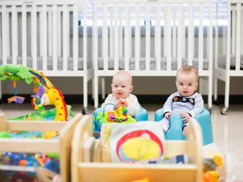 two babies sitting in a playroom