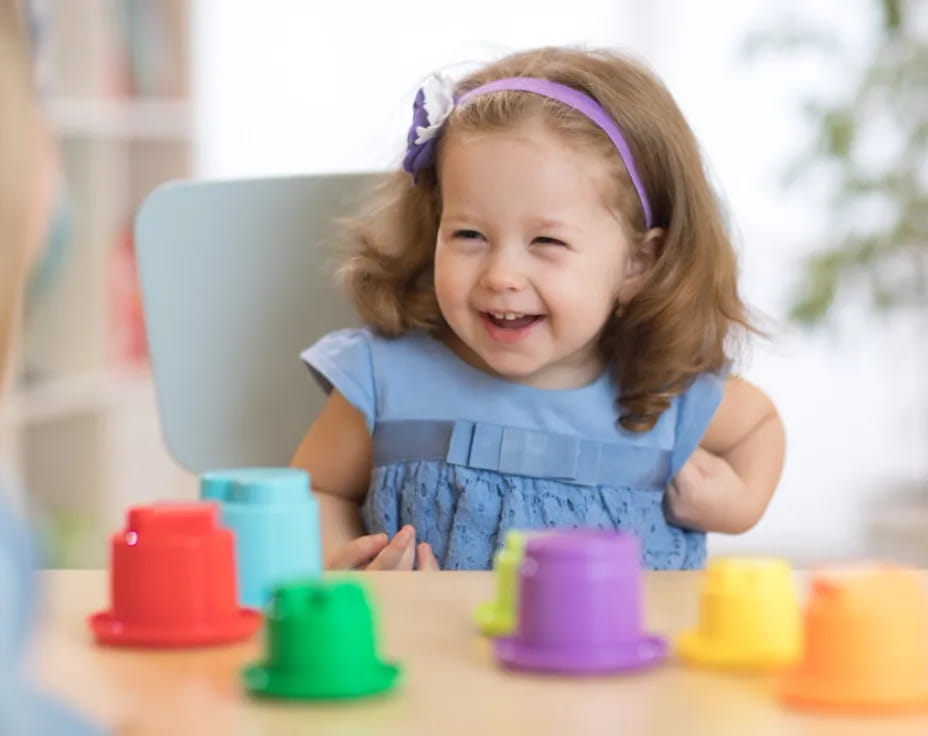 a little girl sitting at a table
