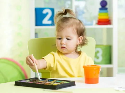 a little girl sitting at a table