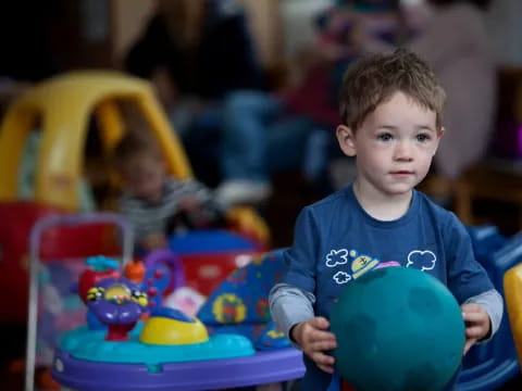 a boy holding a blue ball