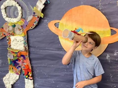 a boy standing next to a large toy
