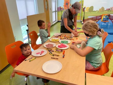 a group of kids eating at a table