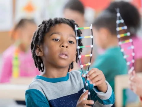 a young girl holding a pencil