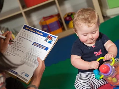 a person reading a book to a child