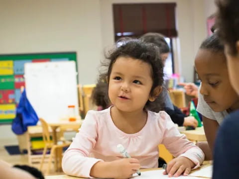 a young girl writing on a paper