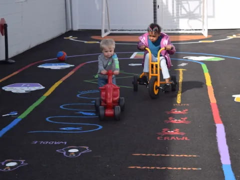 two kids riding toy vehicles