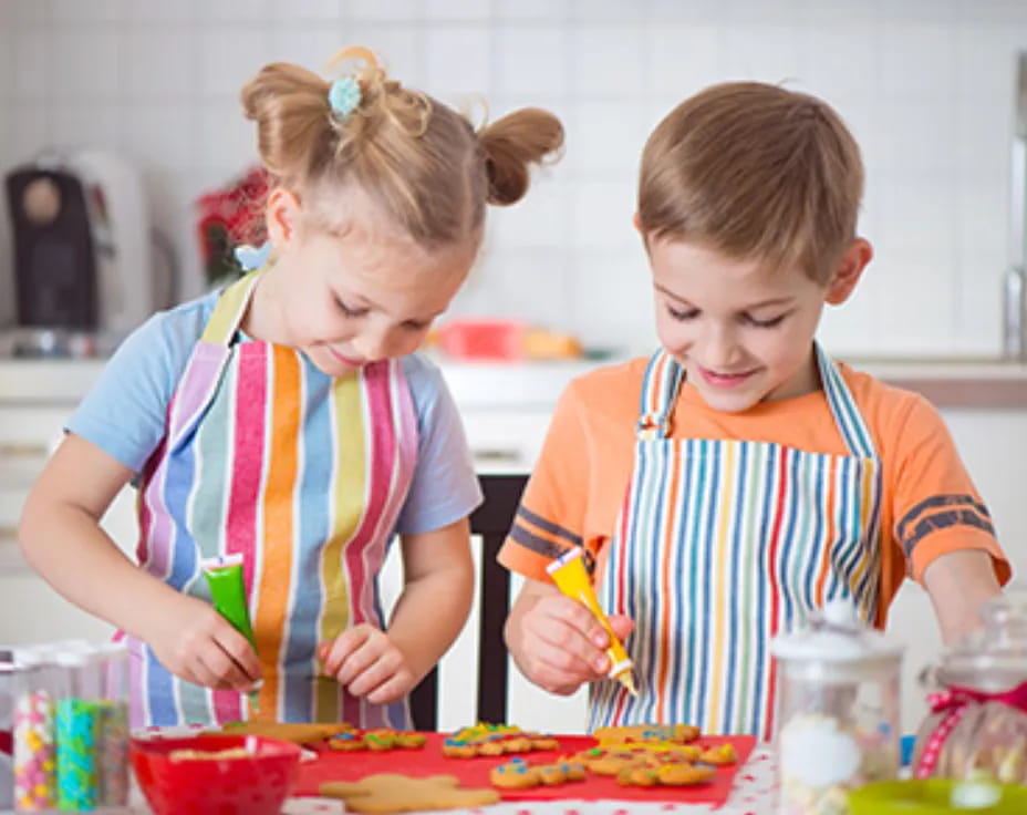 a couple of children making food