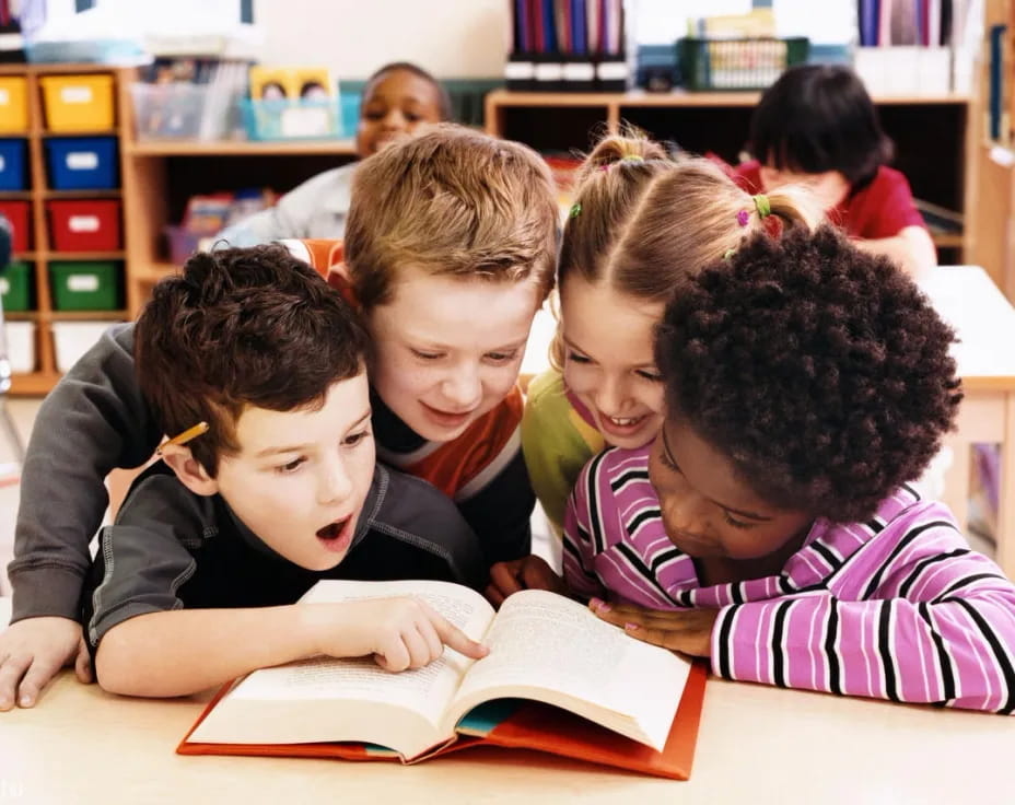 a group of children reading a book