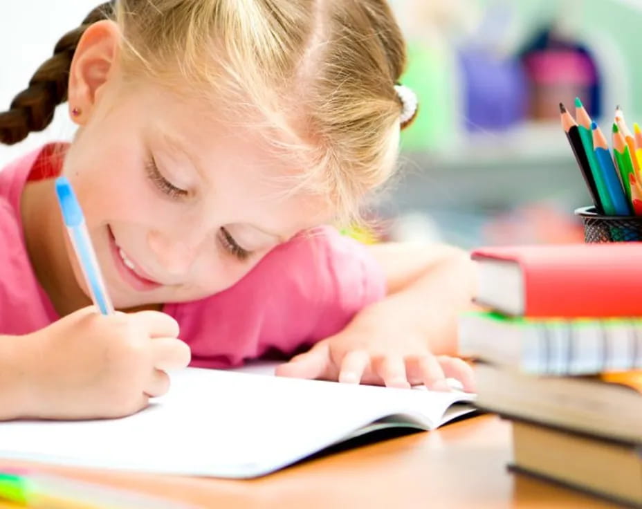 a young girl writing on a book