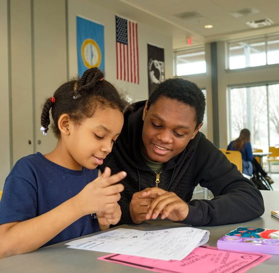 a person and a child looking at a book