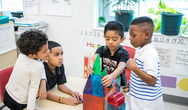 a group of children looking at a paper