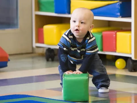 a baby sitting on a toy