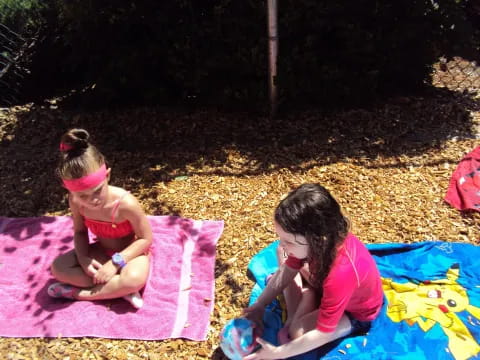 two girls sitting on a blanket