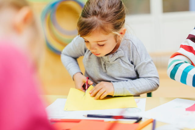 a young girl writing on a book