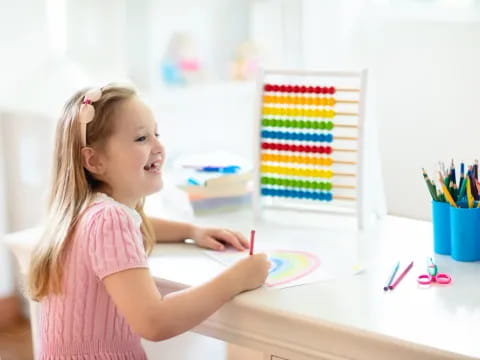 a girl coloring on a paper