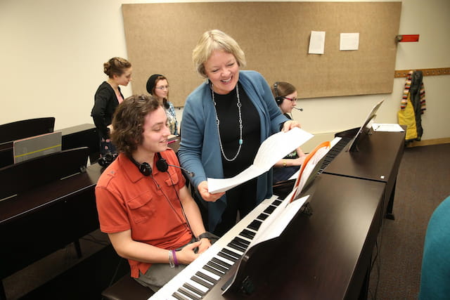 a group of people playing piano