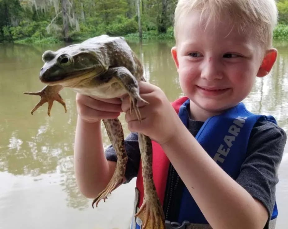 a boy holding a fish