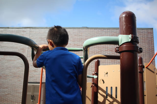 a boy standing next to a large metal pipe