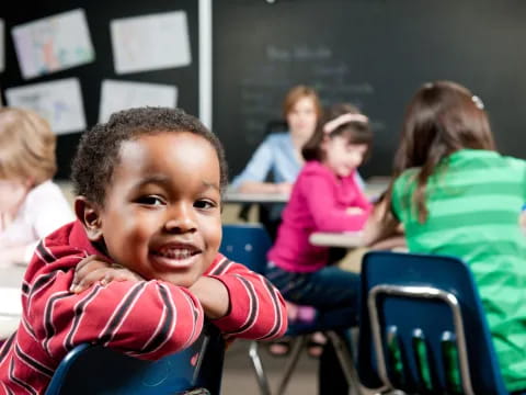a young boy sitting in a classroom