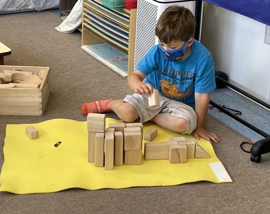 a child sitting on a yellow block