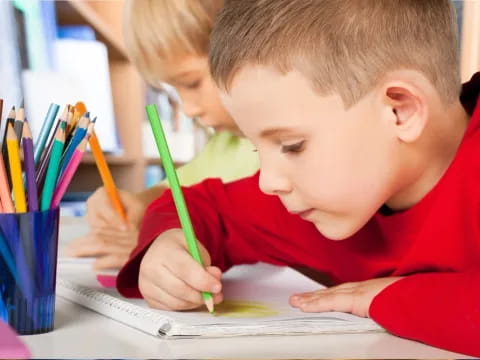 a young boy coloring on a paper