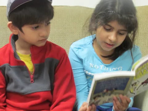 a boy and girl reading a book