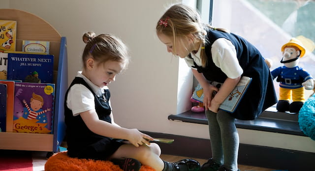 a young girl reading a book to a young girl