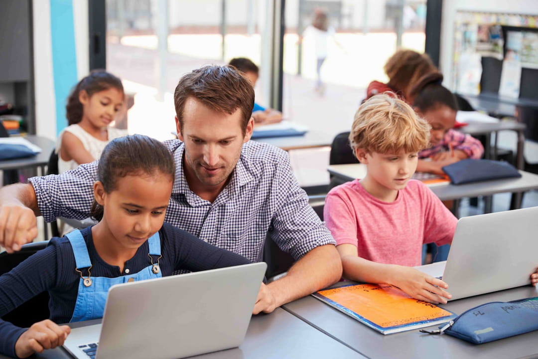 a person and a few children using a laptop