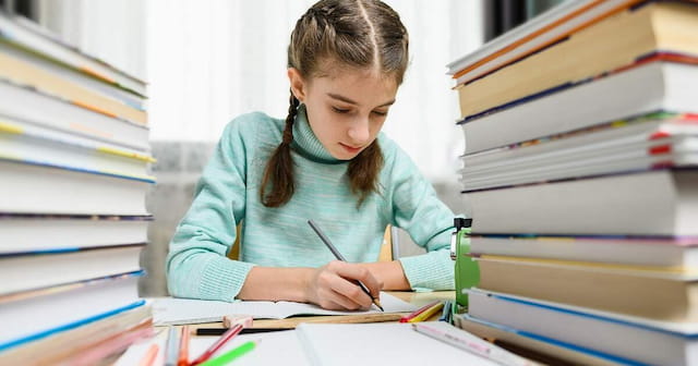 a young girl writing on a book