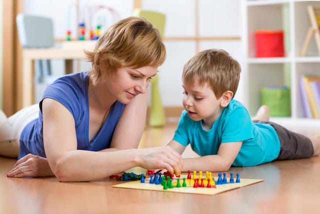a person and a boy playing with a toy train