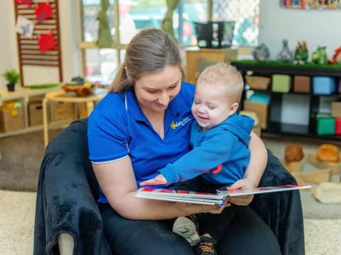 a person reading a book to a child