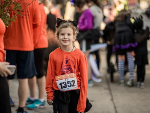a young girl wearing a number tag