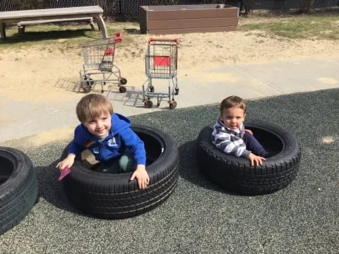 two kids playing on tires