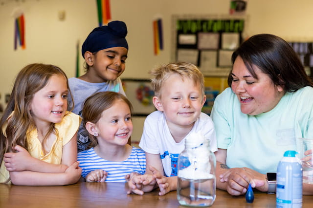 a person and several children sitting at a table