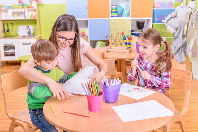 a person and two children sitting at a table