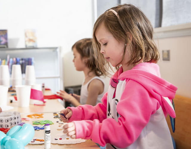 a person helping a child paint