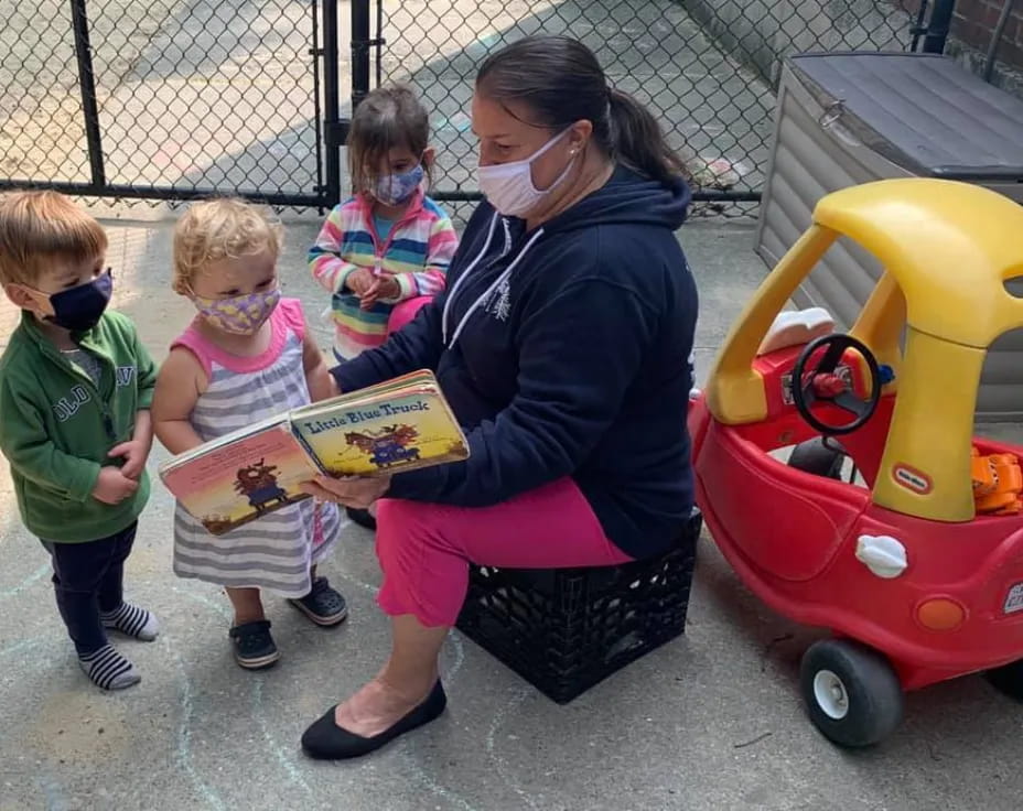 a person reading a book to children