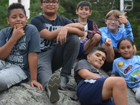 a group of boys sitting on a rock