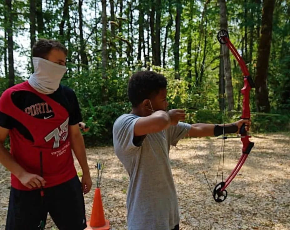 a man shooting a bow and arrow