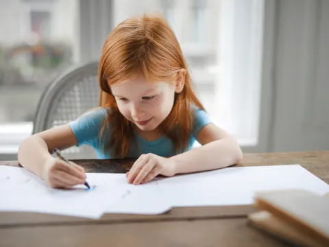 a young girl writing on a book