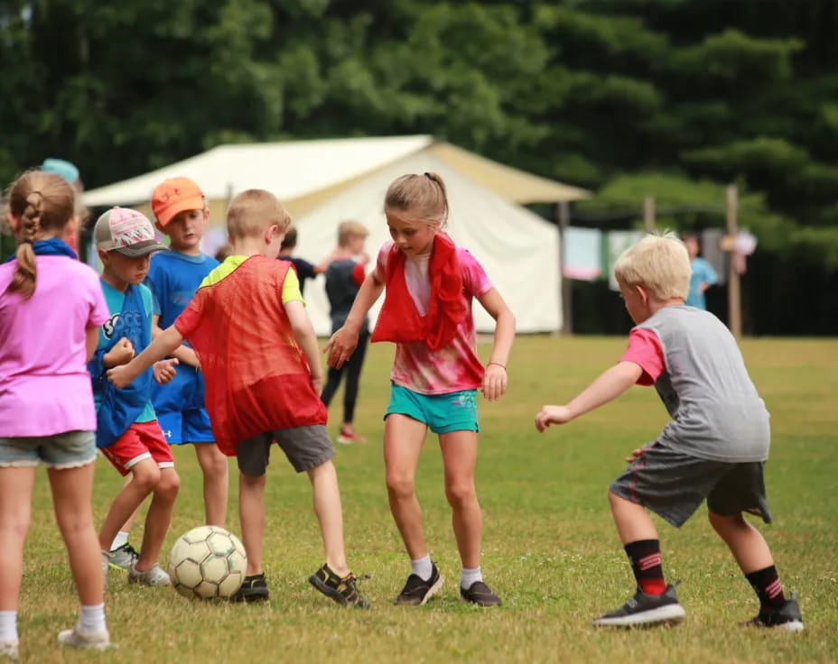 kids playing football in the grass