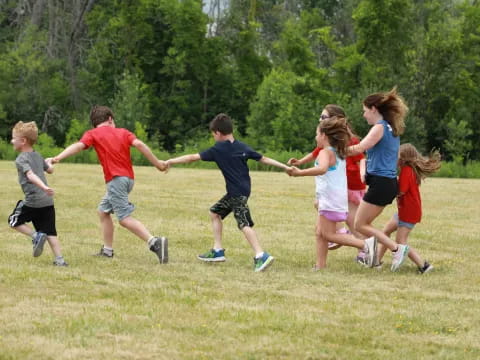 a group of kids running in a field