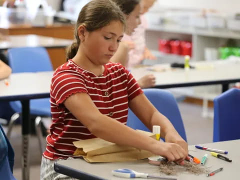 a young girl sitting at a desk