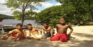 a group of boys sitting on a beach