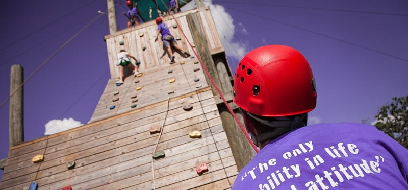 a group of people climbing a wooden structure
