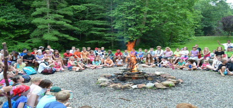 a group of people sitting on rocks by a river