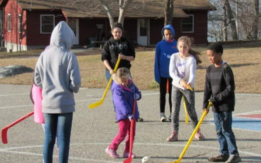a group of people holding brooms